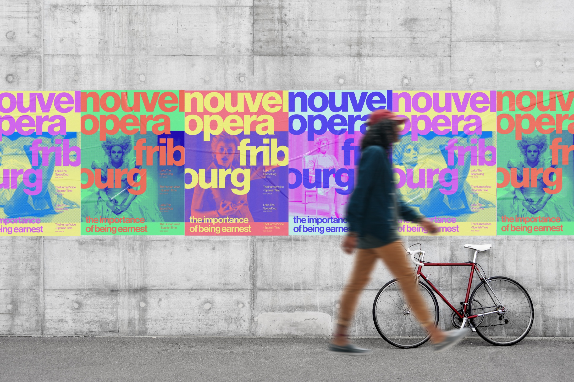 Nouvel Opera Fribourg posters on a wall beside a cyclist